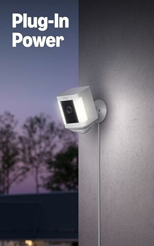 Wall-mounted plug-in security camera at dusk