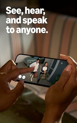 Person viewing security camera feed on smartphone.